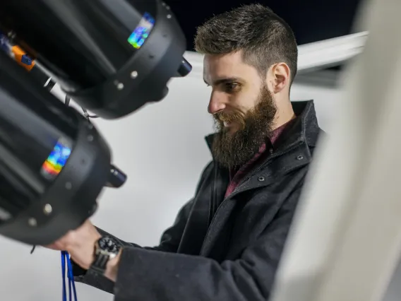 Photo of Tanner Campbell working on telescopes.