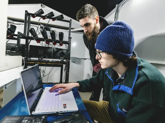 Photo of a student at a laptop in an observatory.