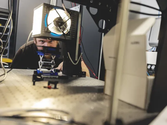 Photo of a researcher looking at equipment in a lab.