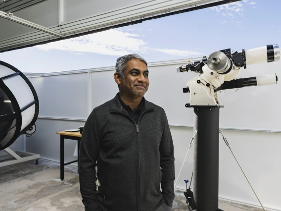Photo of Vishnu Reddy with a telescope
