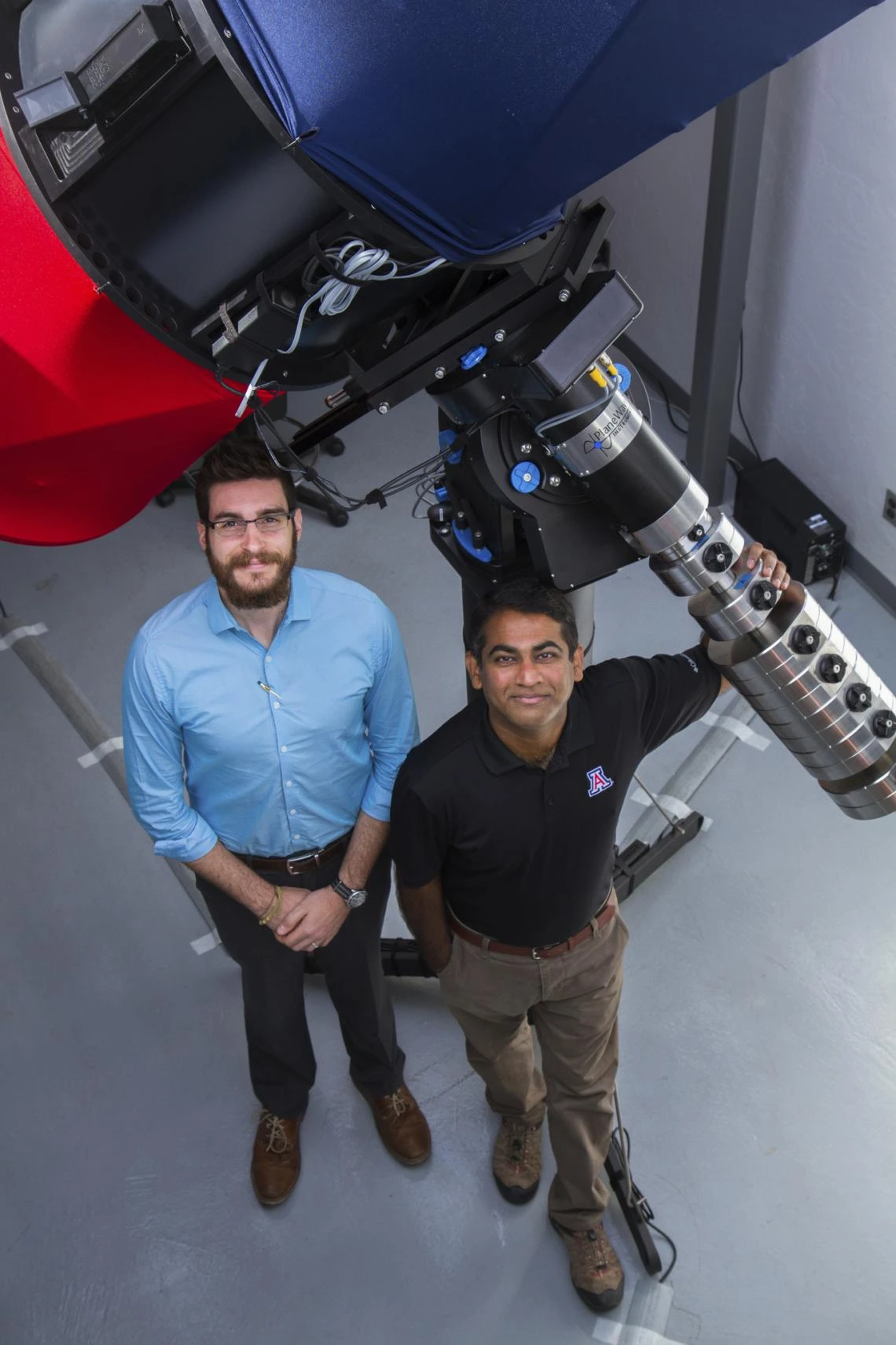 Researchers stand with telescope they used.