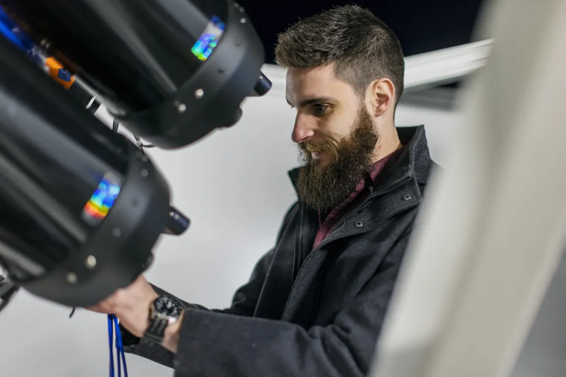 Photo of a student working on telescope equipment.