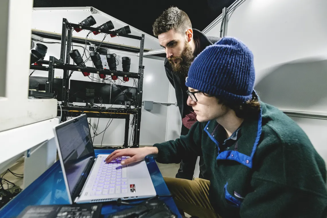 Photo of a student at a laptop in an observatory.