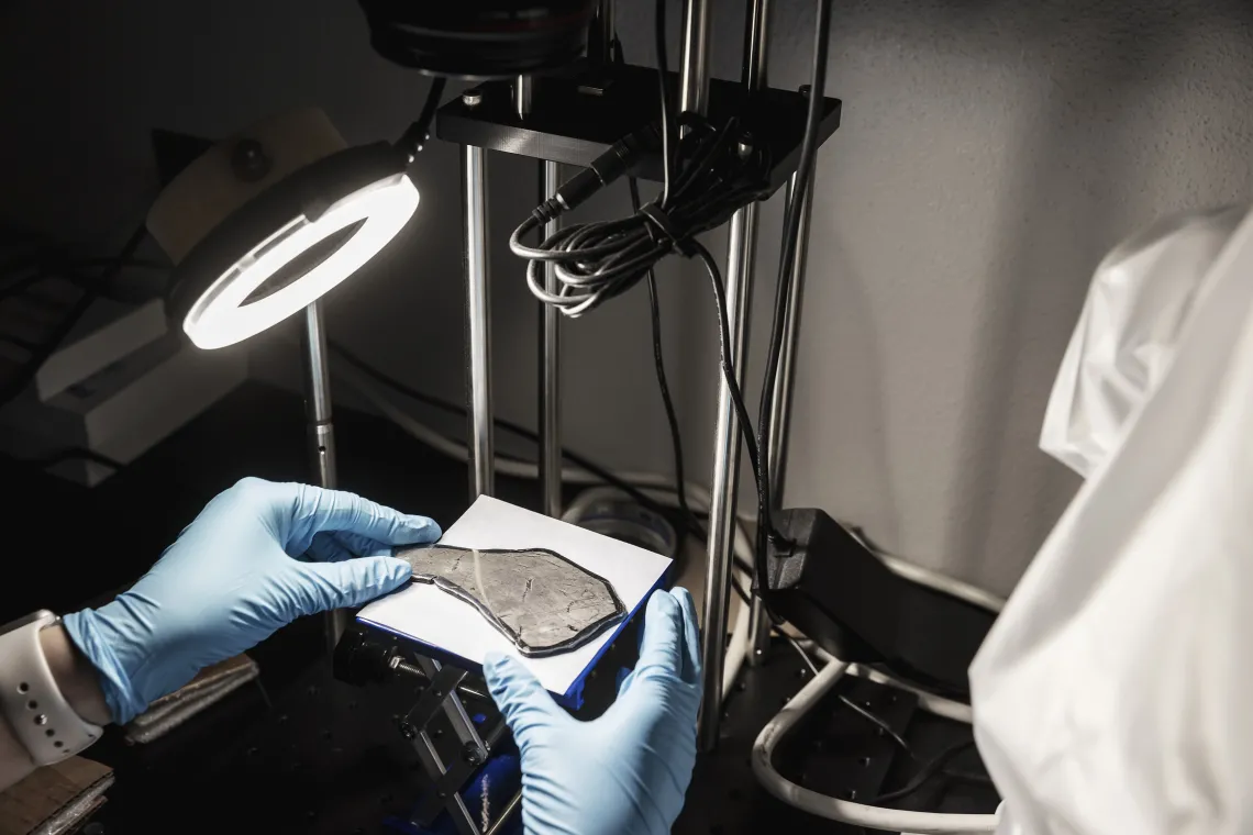 Photo of a researcher examining an object in the lab.