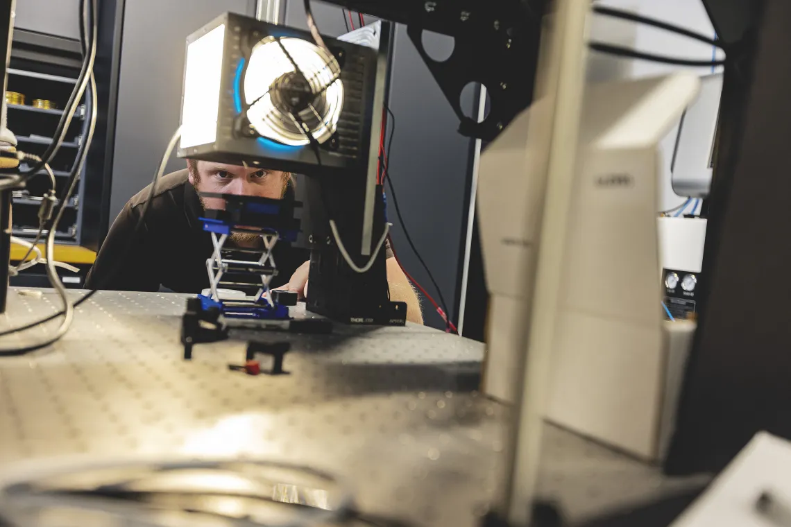 Photo of a researcher looking at equipment in a lab.