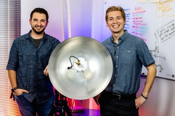 Photo of students with a dish for radio frequency research.