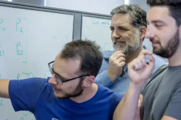 Photo of Roberto Furfaro in his lab with postdoctoral associates. 