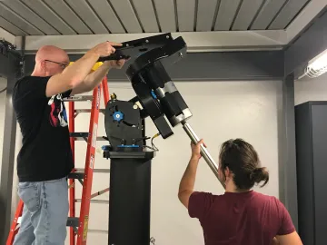 Photo of students building a telescope.