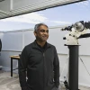 Photo of Vishnu Reddy with a telescope